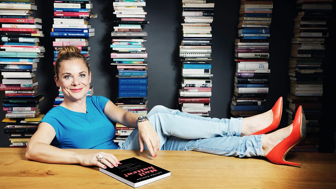 LIKE Publishing Verlegerin Anitra Eggler Foto: Andreas Jakwerth Foto von LIKE Publishing Verlegerin und Autorin Anitra Eggler vor einer Bücherwand